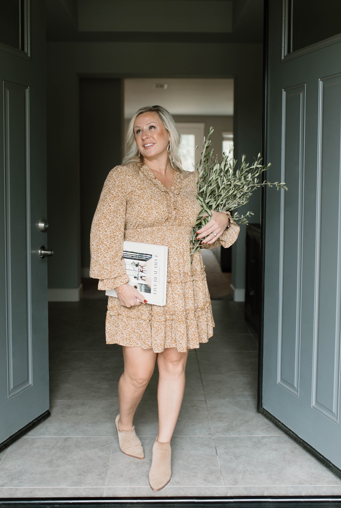Cassie in a doorway holding olive branches